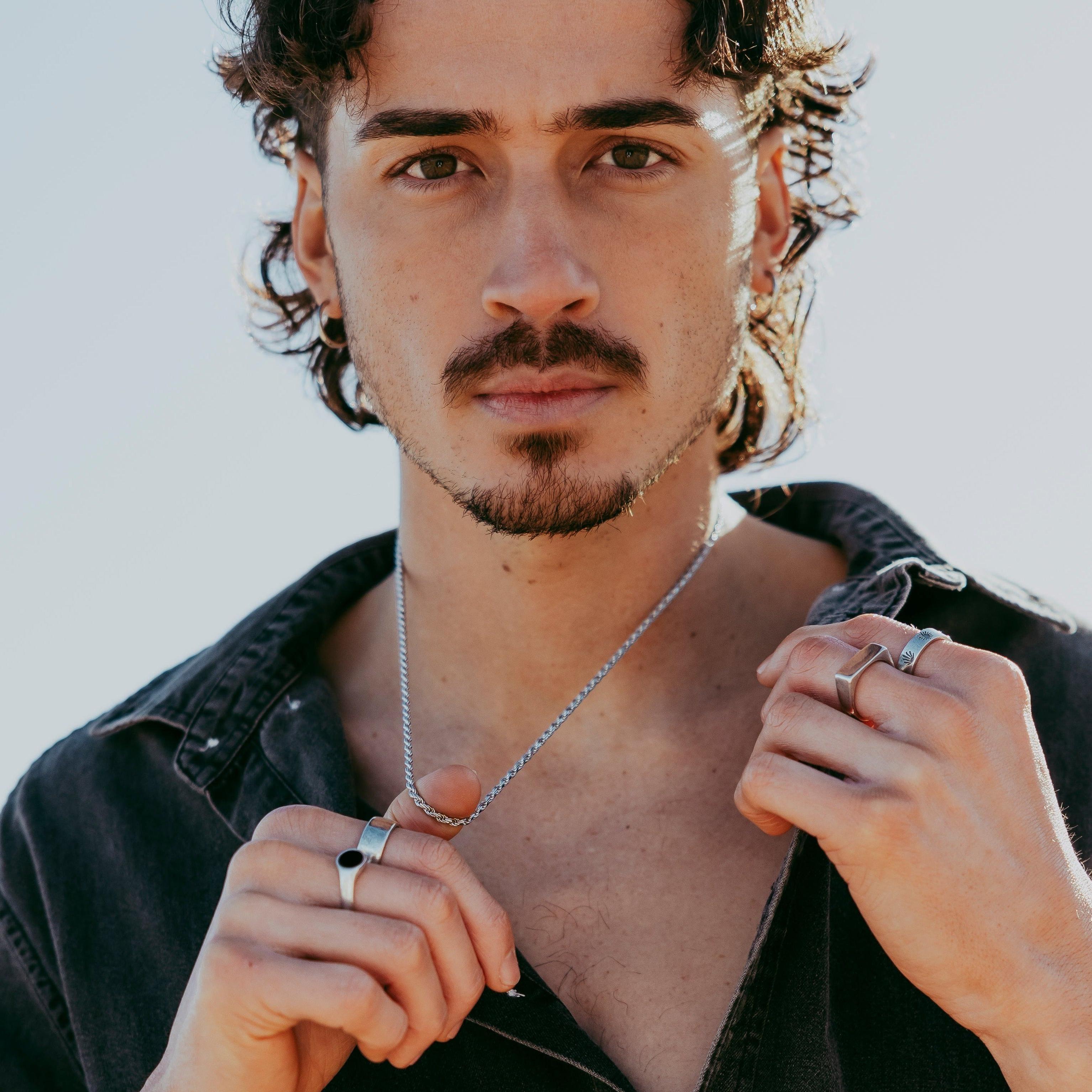 Portrait of model with silver hoop earrings and neutral top