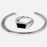 Silver ring with a black gemstone on a white background