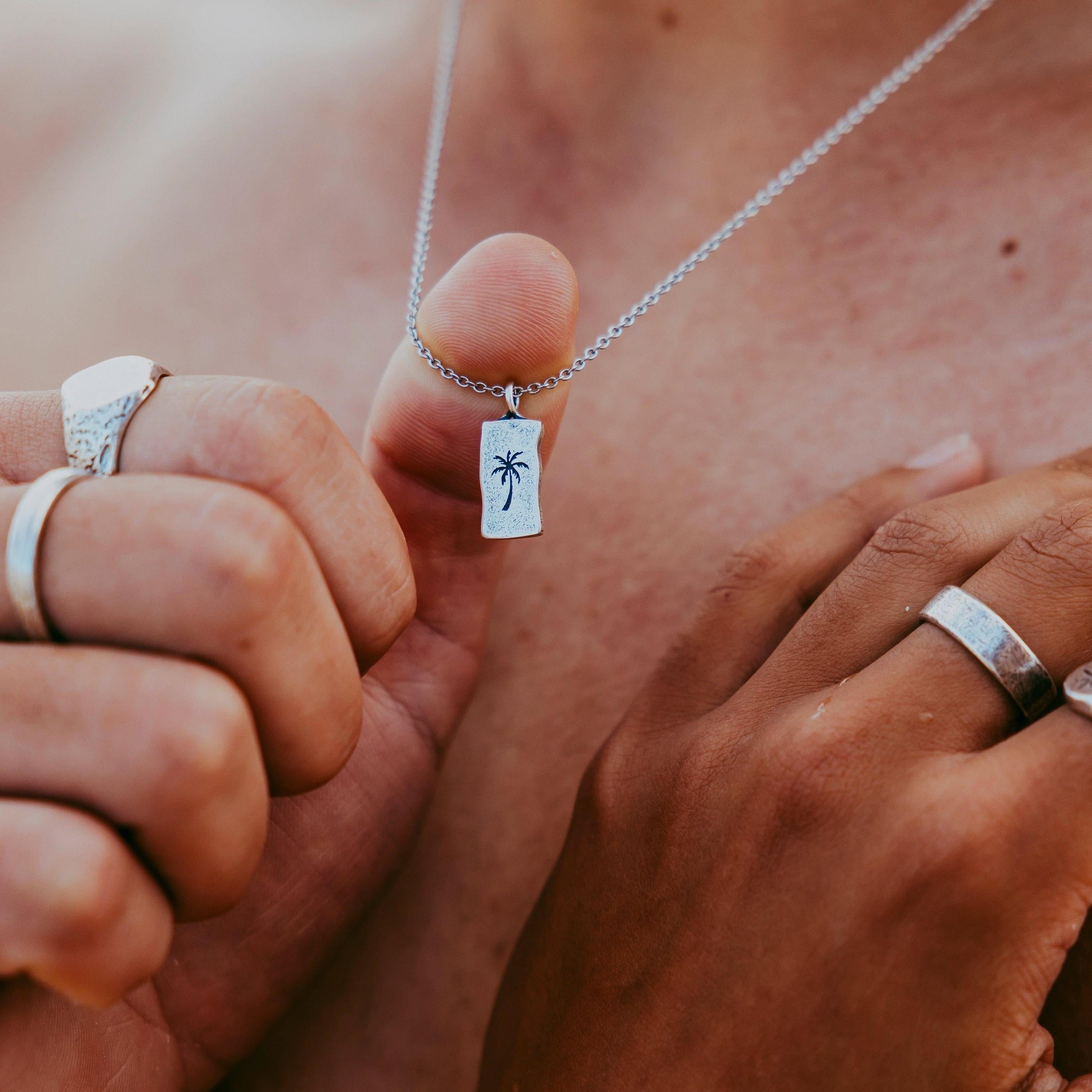 Detailed close-up of engraved pendant necklace on white